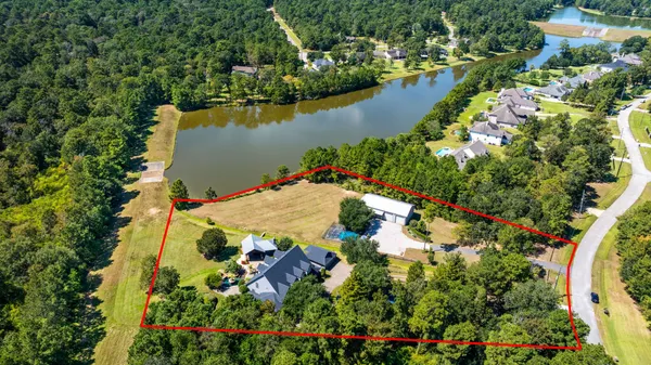 an aerial view of residential houses with outdoor space and lake view