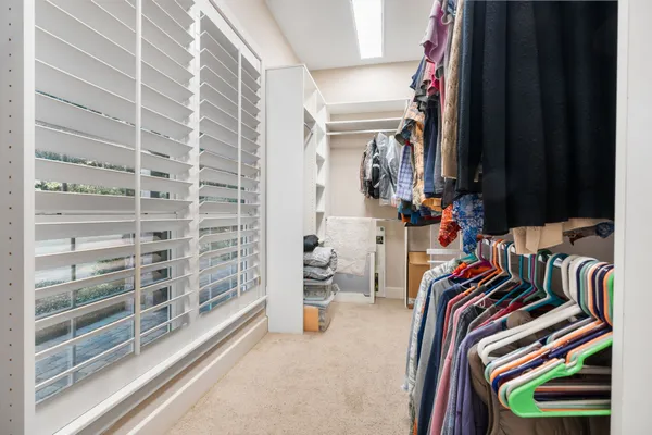 a view of walk in closet with clothes and shoes