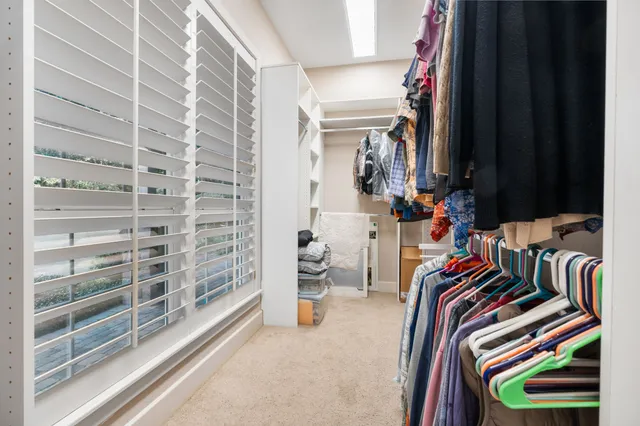 a view of walk in closet with clothes and shoes