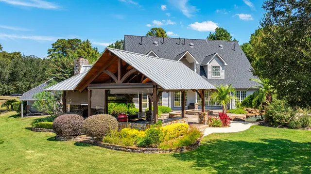 a view of a house with pool and sitting area