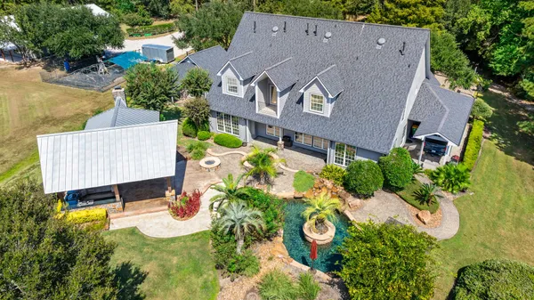 an aerial view of a house with a yard and garden