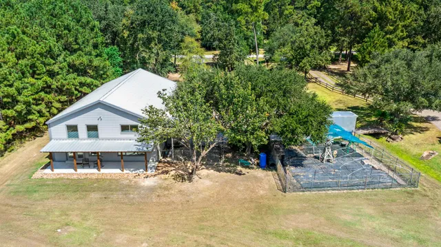 a view of a house with a backyard and a tree