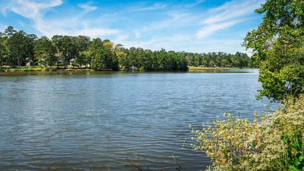 an aerial view of a house with a yard and lake view