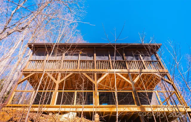 a view of house with wooden fence and trees