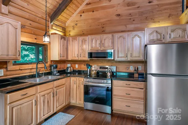 a kitchen with granite countertop a sink stainless steel appliances and cabinets