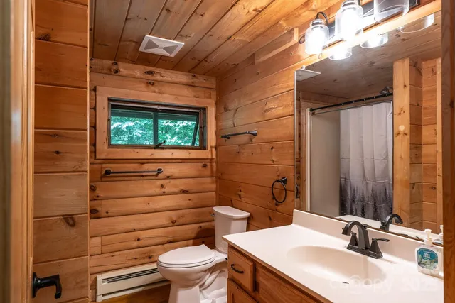 a bathroom with a sink a toilet and shower curtain