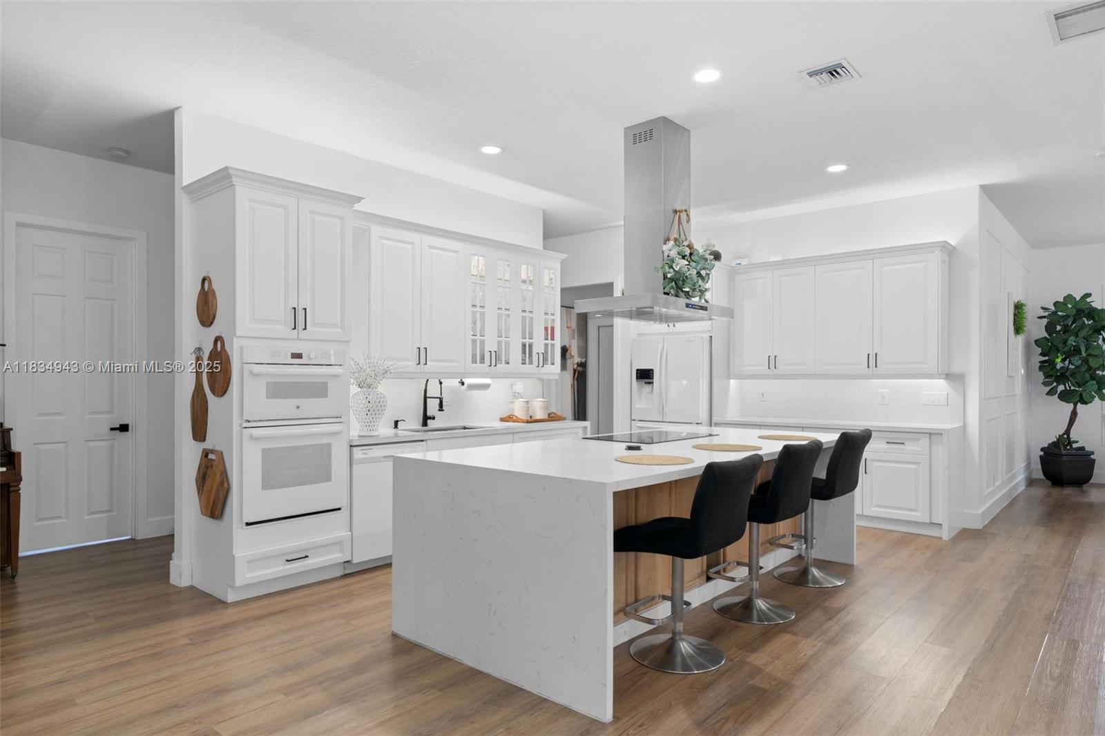 14501 Southwest 33rd Court Miramar, FL 33027 - Photo 16 of 91 a kitchen with white cabinets stainless steel appliances and wooden floor