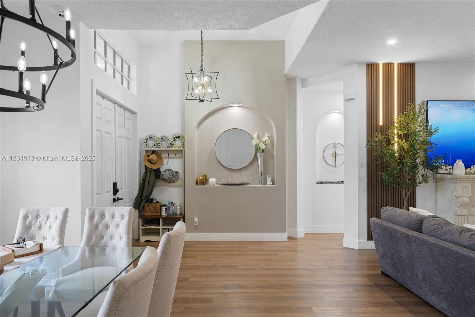 14501 Southwest 33rd Court Miramar, FL 33027 - Photo 6 of 91 a living room with couches a mirror and a dining table with wooden floor