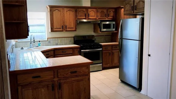 a kitchen with a refrigerator and a stove