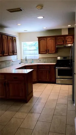 a kitchen with stainless steel appliances granite countertop a sink and cabinets
