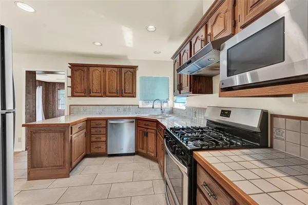 a kitchen with stainless steel appliances granite countertop a stove and a sink