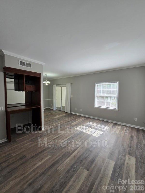 5949 Quail Hollow Road, Unit D Charlotte, NC 28210 - Photo 5 of 34 a view of an empty room with a window and wooden floor