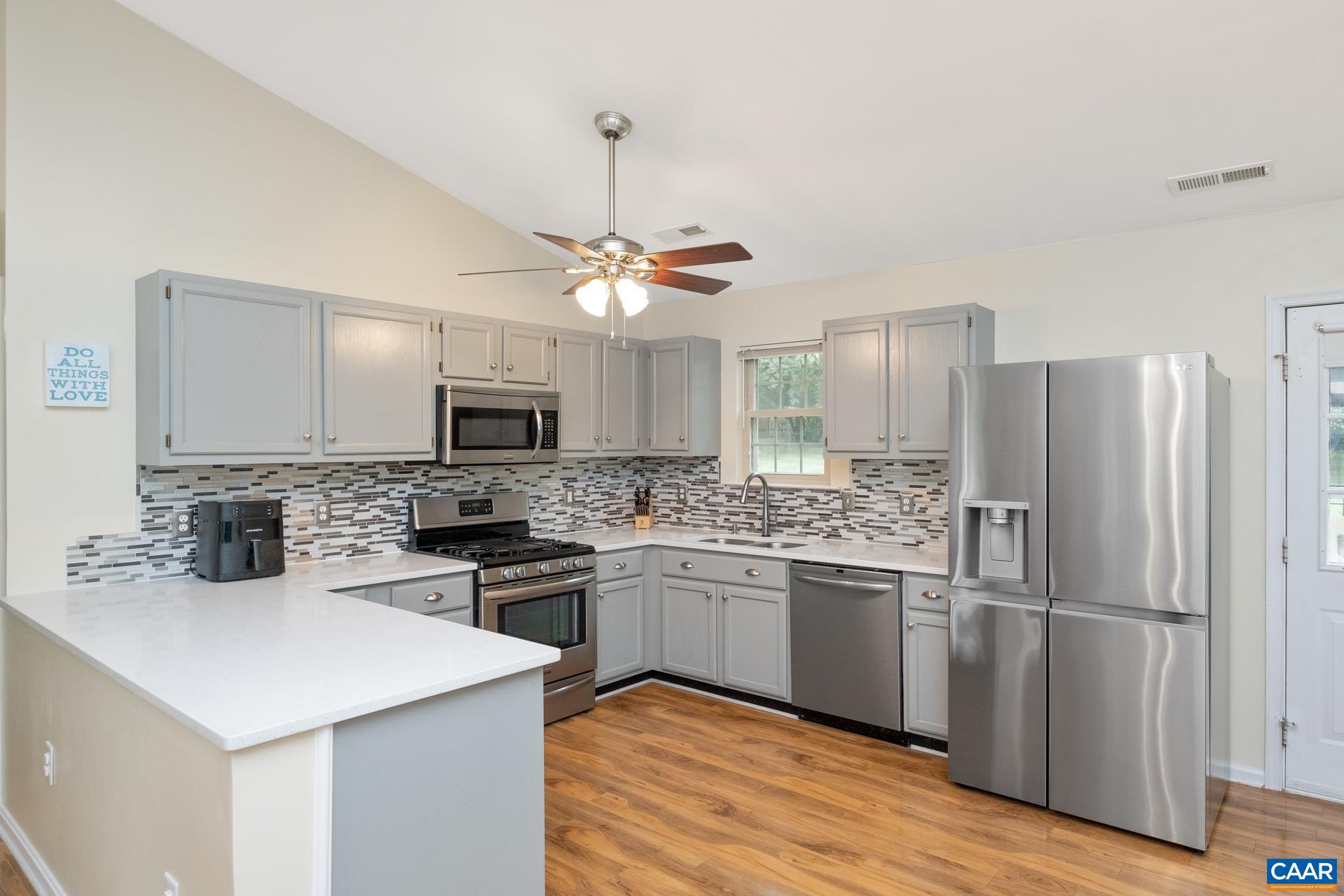 17 Jonquil Road Ruckersville, VA 22968 - Photo 11 of 33 a kitchen with stainless steel appliances granite countertop a refrigerator a stove a sink dishwasher a oven with a dining table and chairs