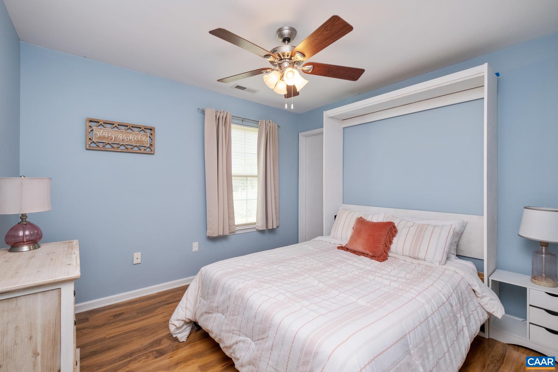 17 Jonquil Road Ruckersville, VA 22968 - Photo 24 of 33 a bedroom with a large bed and a chandelier