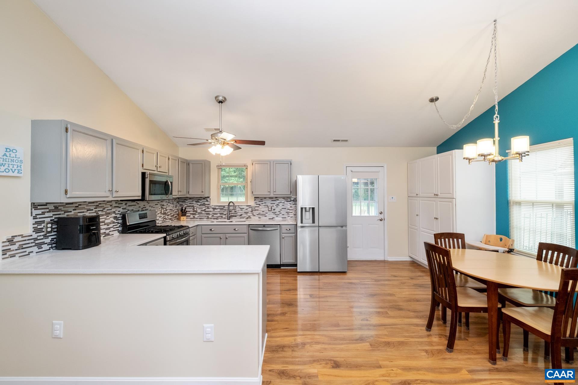17 Jonquil Road Ruckersville, VA 22968 - Photo 10 of 33 a kitchen with stainless steel appliances kitchen island granite countertop a table chairs and a refrigerator