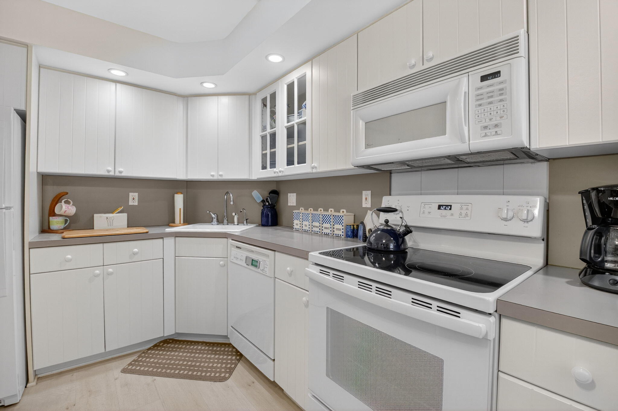 1 Harbourside Drive, Unit 4205 Delray Beach, FL 33483 - Photo 19 of 97 a kitchen with white cabinets and sink