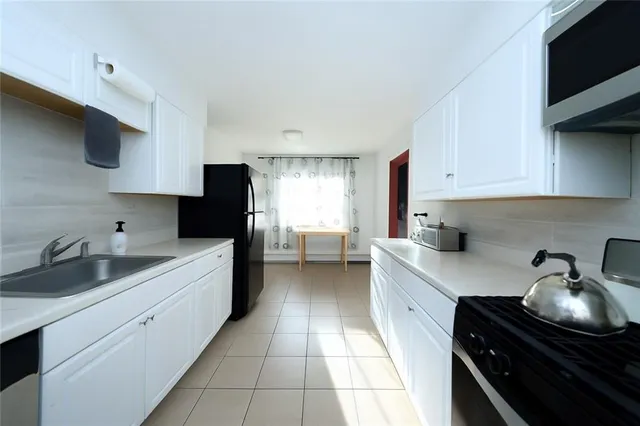 a kitchen with sink a stove and cabinets