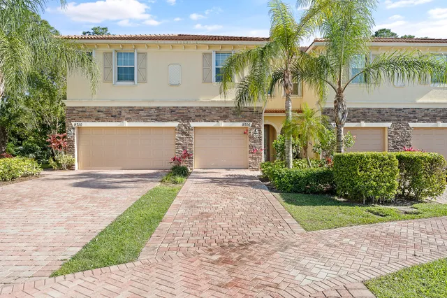 a front view of a house with a garden and a garage
