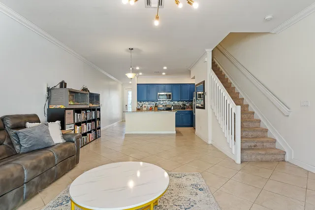 a living room with furniture and kitchen view