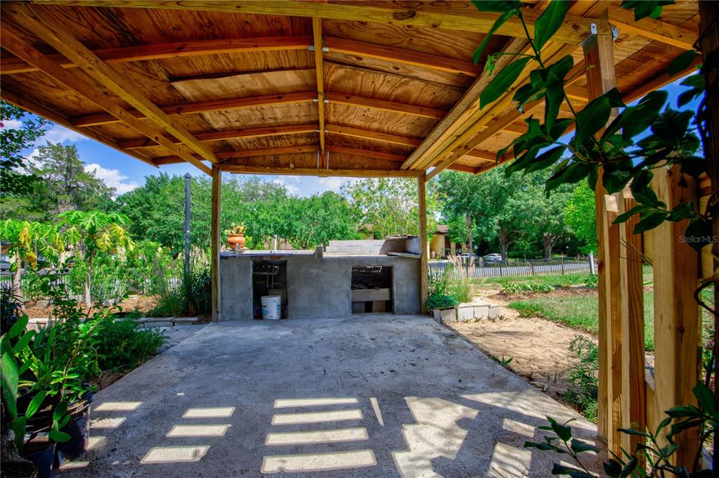 567 Silver Course Run Ocala, FL 34472 - Photo 47 of 95 a view of a patio with table and chairs under an umbrella with a small yard
