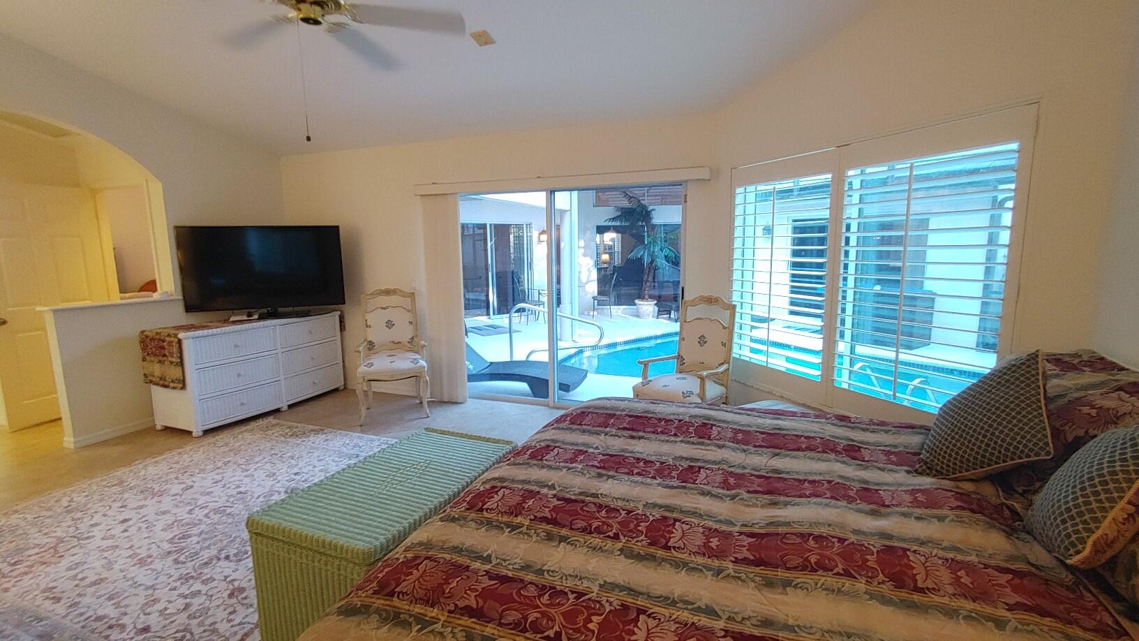 16461 Riverwind Drive Jupiter, FL 33477 - Photo 21 of 45 a bedroom with a bed television and a large window