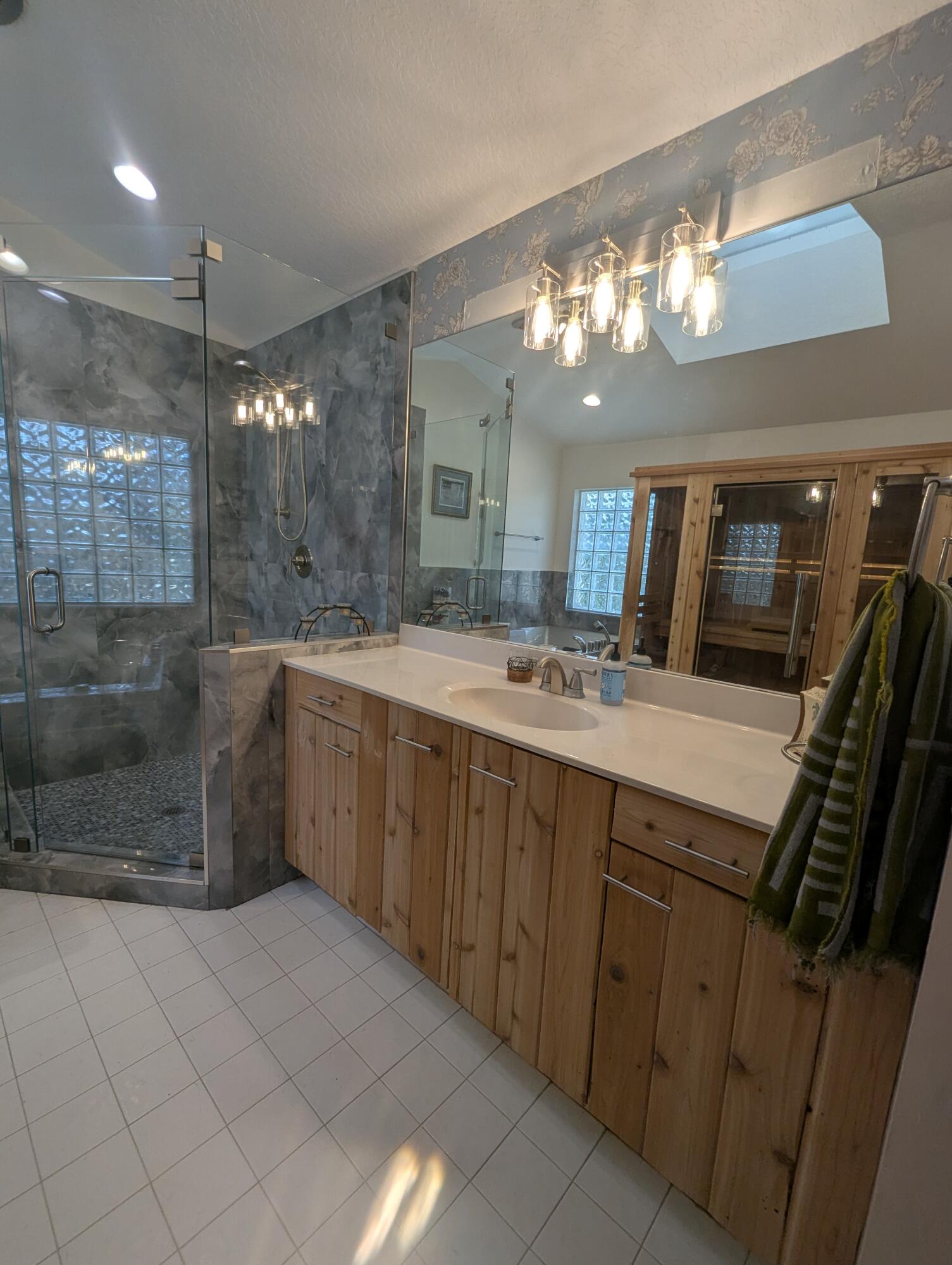 16461 Riverwind Drive Jupiter, FL 33477 - Photo 25 of 45 a bathroom with a sink a large mirror and a shower