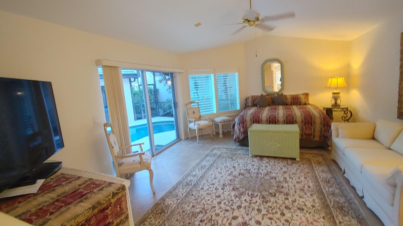 16461 Riverwind Drive Jupiter, FL 33477 - Photo 28 of 45 a living room with a couch and a flat screen tv