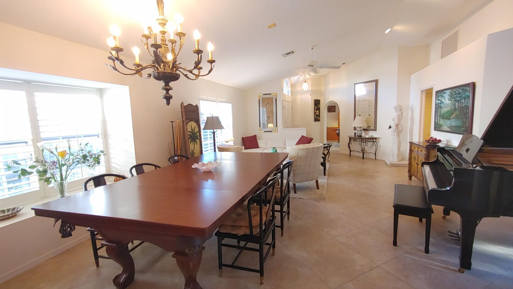 16461 Riverwind Drive Jupiter, FL 33477 - Photo 4 of 45 a view of a dining room and livingroom with furniture wooden floor a rug a potted plant and a chandelier