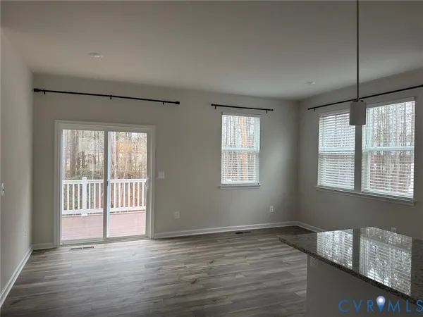 a view of a kitchen and an empty room with a window