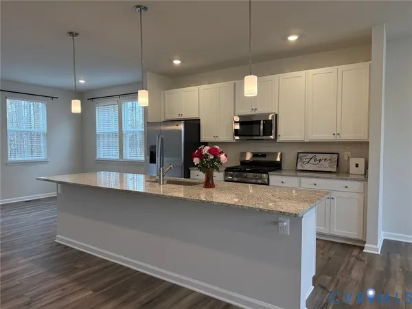 a kitchen with stainless steel appliances granite countertop a sink a refrigerator and a granite counter tops