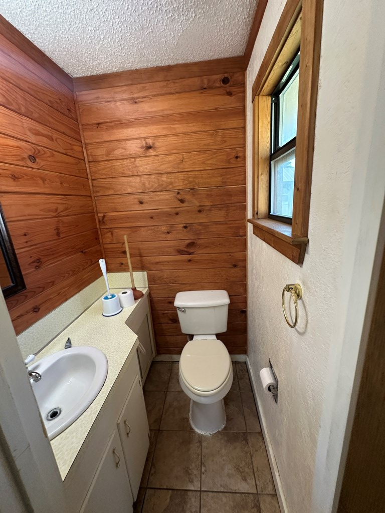 104 South Ave B Mason, TX 76856 - Photo 18 of 26 a bathroom with a granite countertop toilet and a sink
