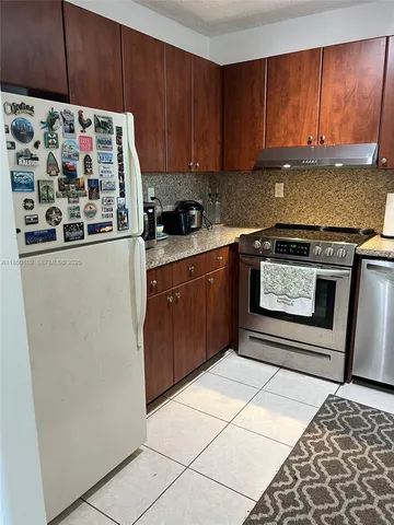 a kitchen with stainless steel appliances granite countertop a refrigerator and a stove top oven