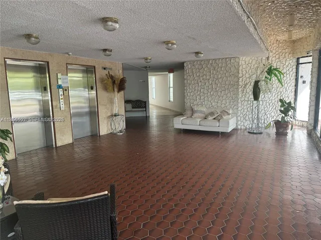 a view of a livingroom with furniture wooden floor and a bathroom