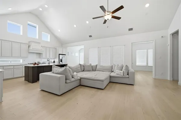 a living room with furniture kitchen view and a chandelier