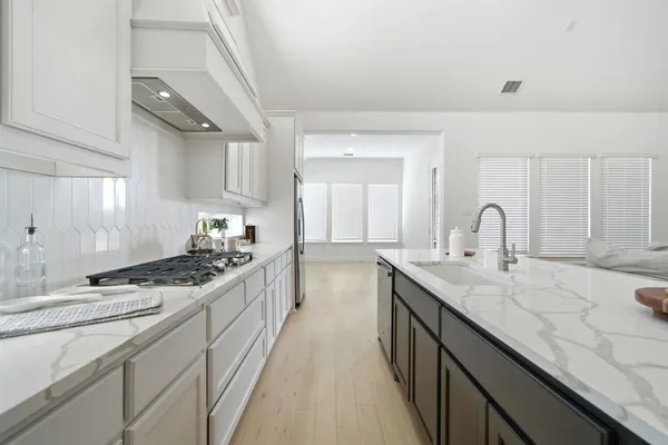 a kitchen with granite countertop a sink stove and cabinets