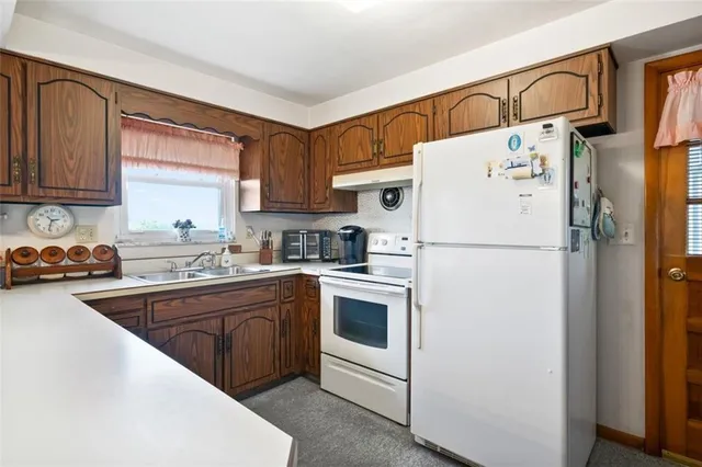 a kitchen with a refrigerator a sink and cabinets