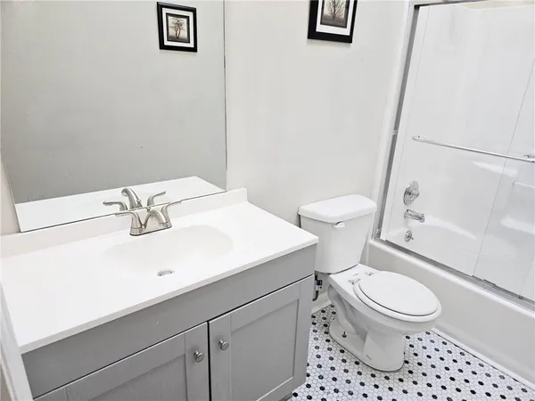 a bathroom with a sink a toilet and a mirror