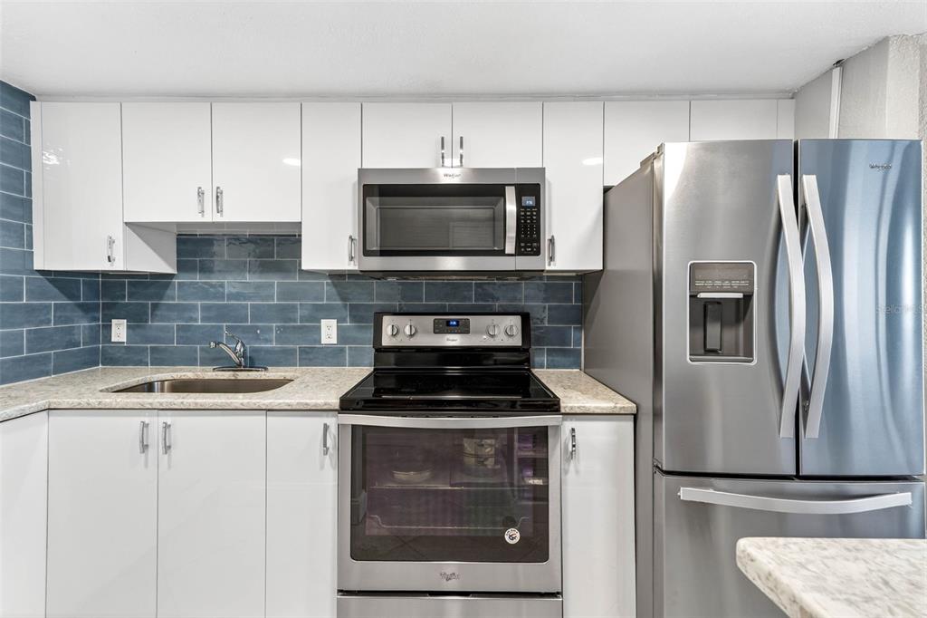 470 3rd Street South, Unit 318 St. Petersburg, FL 33701 - Photo 14 of 45 a kitchen with cabinets stainless steel appliances and a sink