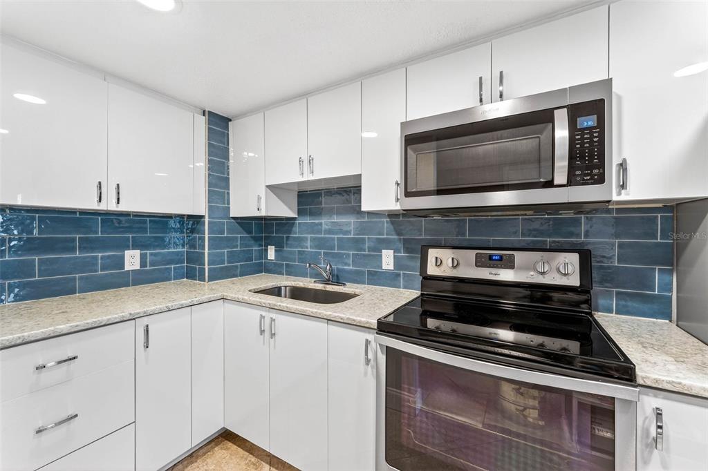 470 3rd Street South, Unit 318 St. Petersburg, FL 33701 - Photo 15 of 45 a kitchen with appliances a sink and cabinets