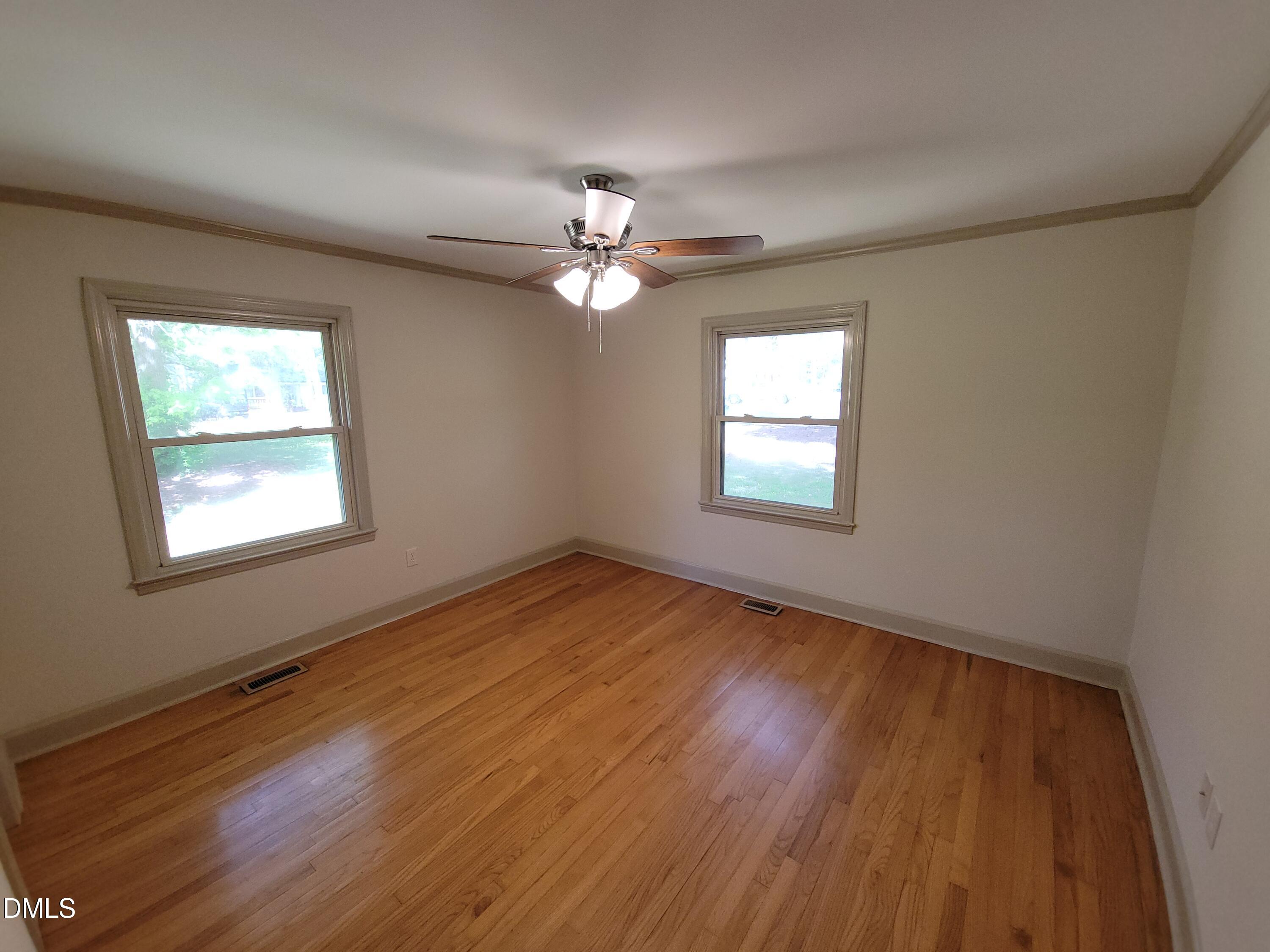7000 Holly Springs Road Raleigh, NC 27606 - Photo 17 of 24 a view of empty room with wooden floor and fan