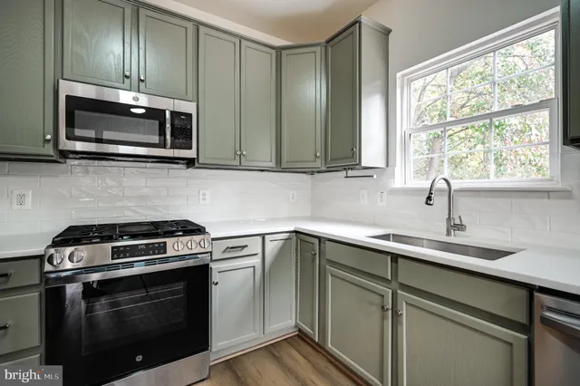 a kitchen with cabinets stainless steel appliances and window