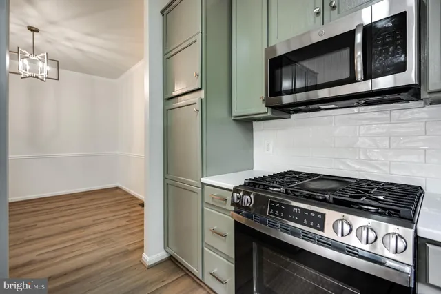 a kitchen with stainless steel appliances granite countertop a stove and a microwave
