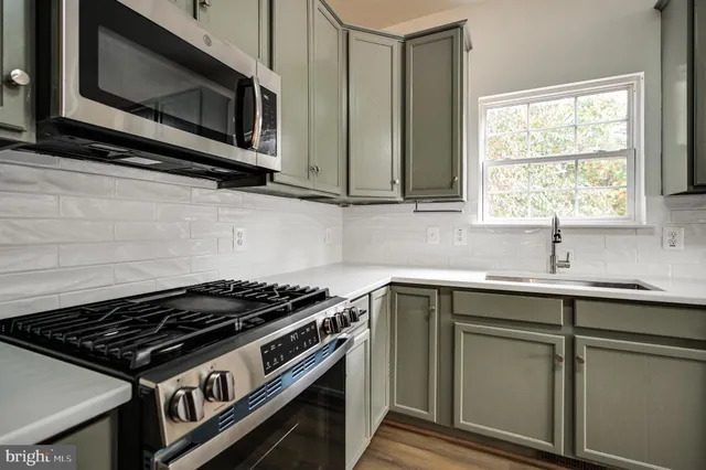 a kitchen with stainless steel appliances a sink stove and microwave