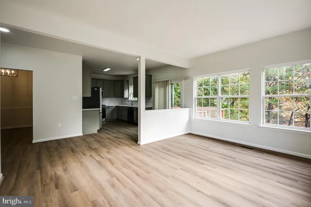 a view of empty room with wooden floor and windows
