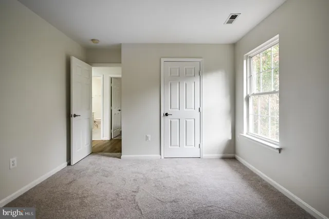 an empty room with windows and closet