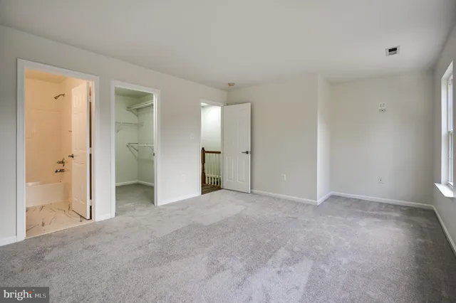 an empty room with closet and a bathroom
