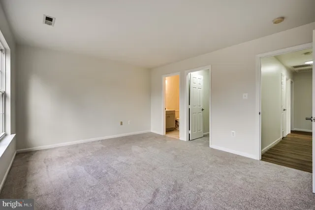 an empty room with closet and wooden floor