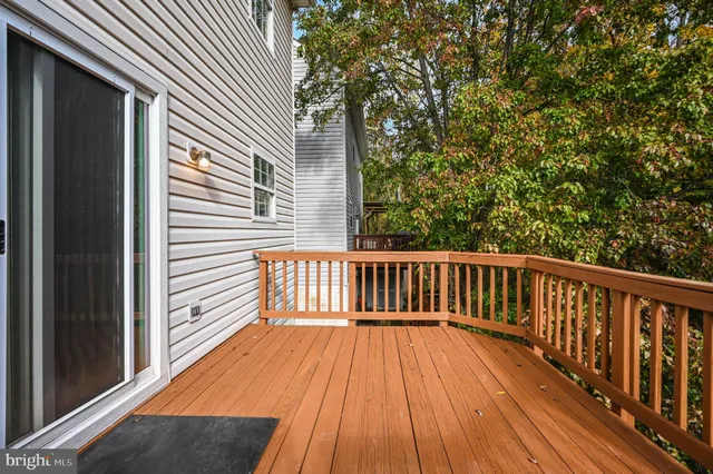 a balcony with wooden floor and yard in the back