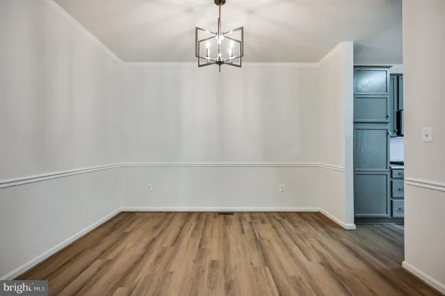 a view of a room with wooden floor and white walls