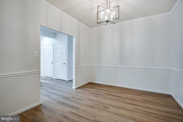 a view of a room with wooden floor and white walls